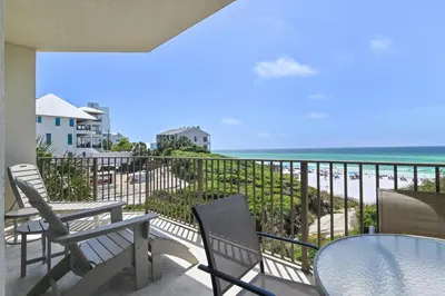 a balcony with chairs and a table and the ocean at Legacy 202 in Santa Rosa Beach