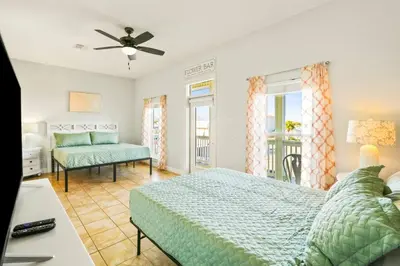 a bedroom with a bed and a couch and windows at PCB Private Pool Home, Sleeps 14, Dog Friendly, Near Beach in Panama City Beach