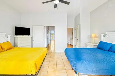 a bedroom with two beds and a flat screen tv at PCB Private Pool Home, Sleeps 14, Dog Friendly, Near Beach in Panama City Beach
