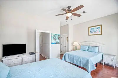 a bedroom with two beds and a flat screen tv at Beach House w/ Private Pool Near PCB | Dog Friendly in Panama City Beach