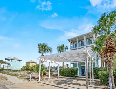 a house on the beach with palm trees at Beach House w/ Private Pool Near PCB | Dog Friendly in Panama City Beach