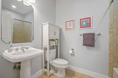 a white bathroom with a sink and a toilet at Dog-Friendly 3BR Beach Retreat | Walk to Shore & Community Pool in Panama City Beach
