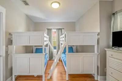a bedroom with two bunk beds and a television at Dog-Friendly 3BR Beach Retreat | Walk to Shore & Community Pool in Panama City Beach