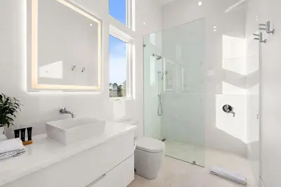 a white bathroom with a sink and a shower at 30a Gulf-View Gem | Stay Gold in Santa Rosa Beach