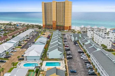 an aerial view of a parking lot with a tall building at Quiet West End PCB Condo w/ Gulf Views, Pool & Easy Beach Access in Panama City Beach