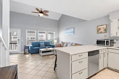 a kitchen and living room with a couch and a ceiling fan at Quiet West End PCB Condo w/ Gulf Views, Pool & Easy Beach Access in Panama City Beach
