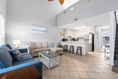 a living room with a couch and a table at Quiet West End PCB Condo w/ Gulf Views, Pool & Easy Beach Access in Panama City Beach