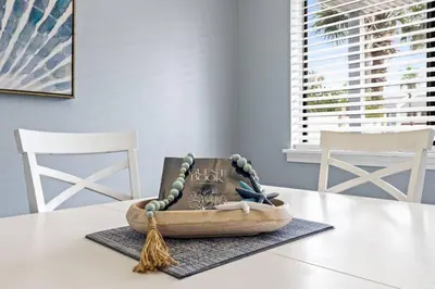a table with a wooden bowl on a table with two chairs at Pet-Friendly Coastal Townhome | Walk to Beach & Local Dining in Panama City Beach