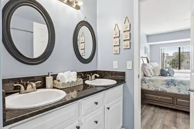 a bathroom with two sinks and two mirrors at Pet-Friendly Coastal Townhome | Walk to Beach & Local Dining in Panama City Beach