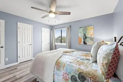 a bedroom with a bed and a ceiling fan at Pet-Friendly Coastal Townhome | Walk to Beach & Local Dining in Panama City Beach