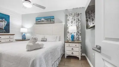 a bedroom with a white bed and two night stands at Renovated Condo 4-Min Walk to Beach & Pools in Panama City Beach