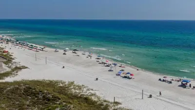 a beach with a lot of people with umbrellas at Renovated Condo 4-Min Walk to Beach & Pools in Panama City Beach