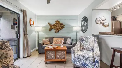 a living room with a couch and a table at Renovated Condo 4-Min Walk to Beach & Pools in Panama City Beach