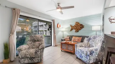 a living room with two chairs and a table at Renovated Condo 4-Min Walk to Beach & Pools in Panama City Beach