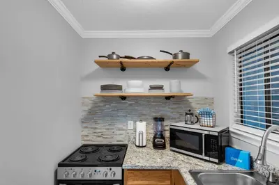a kitchen counter with a stove and a microwave at Pirates Cove Inlet Unit H (0/1) in Panama City Beach