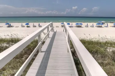 a boardwalk leading to the beach with umbrellas at Pirates Cove Inlet Unit H (0/1) in Panama City Beach