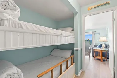 a bedroom with two bunk beds and a table at The Summit 315 in Panama City Beach