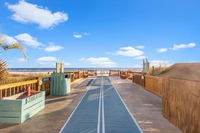 a boardwalk leading to the beach on a sunny day at The Summit 315 in Panama City Beach