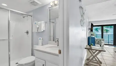 a white bathroom with a toilet and a sink at Low Floor - Remodeled - Beachfront - FLPCB65 in Panama City Beach