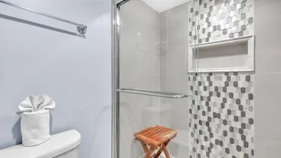 a bathroom with a shower with a glass door at Low Floor - Remodeled - Beachfront - FLPCB65 in Panama City Beach