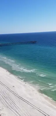 a view of a beach with a pier in the water at Romantic Beachfront Sunsets in Panama City Beach