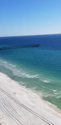 a view of a beach with a pier in the ocean at Romantic Beachfront Sunsets in Panama City Beach