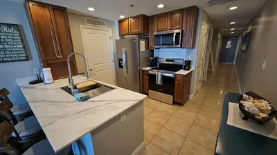 a kitchen with wooden cabinets and a counter top at Romantic Beachfront Sunsets in Panama City Beach