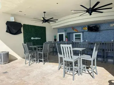 a restaurant with tables and chairs and a green wall at Romantic Beachfront Sunsets in Panama City Beach
