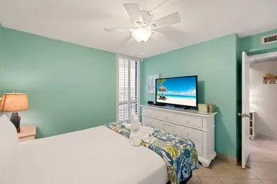 a bedroom with a bed and a flat screen tv at Direct Gulf View 2BR Paradise Found in Panama City Beach