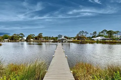 a wooden dock in the middle of a lake at 3BR Grand Lagoon Front Townhome - Private Dock, Resort Amenities & Beach Walk in Panama City Beach