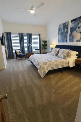 a large bedroom with a large bed and windows at 3BR Grand Lagoon Front Townhome - Private Dock, Resort Amenities & Beach Walk in Panama City Beach