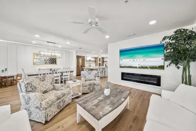 a living room with white furniture and a fireplace at Lagoon Lounge in Seacrest