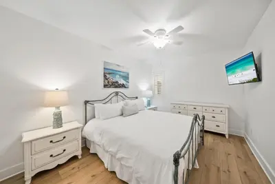 a white bedroom with a bed and a ceiling fan at Lagoon Lounge in Seacrest