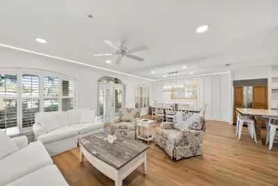 a living room with white furniture and a table at Lagoon Lounge in Seacrest