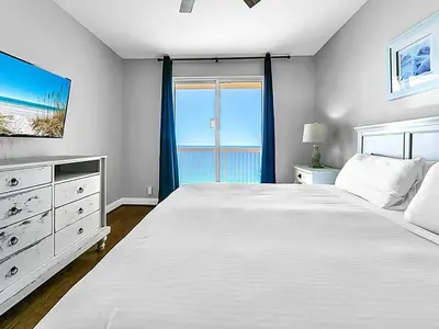a bedroom with a large white bed and a window at Calypso 1-1805 by Emerald Coast Retreats in Panama City Beach