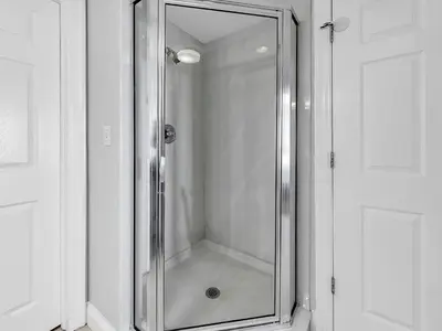 a shower with a glass door in a bathroom at Calypso 1-1805 by Emerald Coast Retreats in Panama City Beach