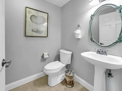 a bathroom with a sink and a toilet and a mirror at Calypso 1-1805 by Emerald Coast Retreats in Panama City Beach