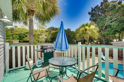 a patio with a table and chairs and an umbrella at 2 Blocks to Beach! Family-Friendly Home in PCB in Panama City Beach