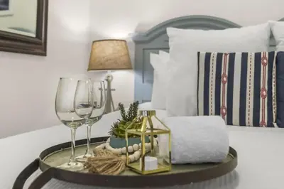 a tray with a wine glass and a table with a bed at The Rosemary Pearl - Pool & Free Beach Shuttle in Seacrest