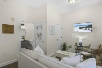 a white living room with a couch and a table at The Rosemary Pearl - Pool & Free Beach Shuttle in Seacrest
