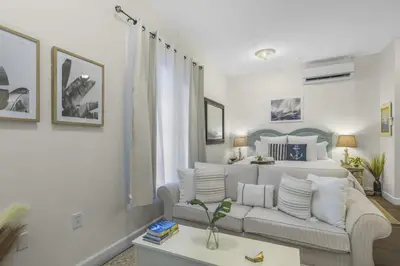 a living room with a couch and a bed at The Rosemary Pearl - Pool & Free Beach Shuttle in Seacrest