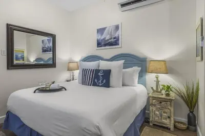 a bedroom with a large white bed and a mirror at The Rosemary Pearl - Pool & Free Beach Shuttle in Seacrest