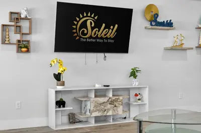 a living room with a black and gold sign on the wall at New Construction - West End PCB - Gated Neighborhood - FLPCB63 in Panama City Beach