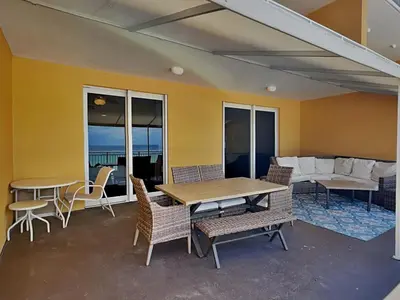 a patio with a table and chairs and a couch at Sterling Reef #106 in Panama City Beach
