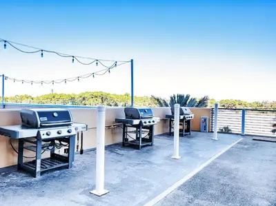 a patio with three ping pong tables and a grill at Sterling Reef #106 in Panama City Beach