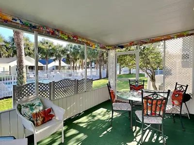 a screened in porch with a table and chairs at Captain Bennetts Cove in Panama City Beach