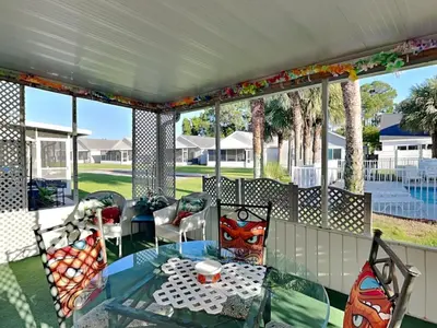 a patio with a glass table and chairs on a porch at Captain Bennetts Cove in Panama City Beach