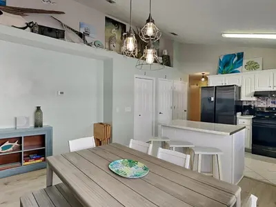 a kitchen with a table and chairs and a kitchen with a refrigerator at Captain Bennetts Cove in Panama City Beach