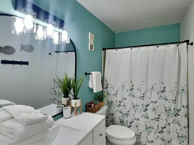 a bathroom with a white toilet and a blue wall at Endless Summer #A30 in Panama City Beach