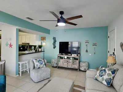 a living room with a couch and a ceiling fan at Endless Summer #A30 in Panama City Beach